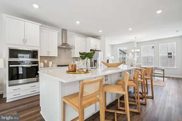 a kitchen with a dining table chairs stainless steel appliances and cabinets