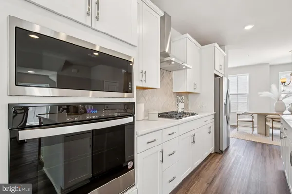 a kitchen with stainless steel appliances kitchen island granite countertop a stove a sink and a microwave