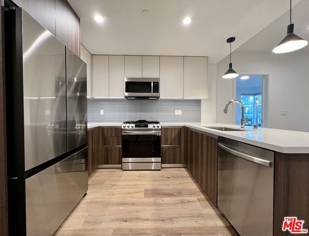 a kitchen with stainless steel appliances kitchen island wooden cabinets and granite counter tops