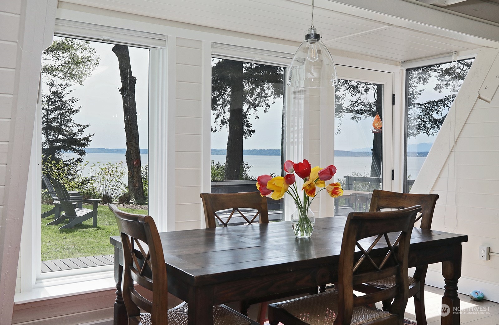 6828 Sills Road Clinton, WA 98236 - Photo 15 of 40 a view of a dining room with furniture window and wooden floor