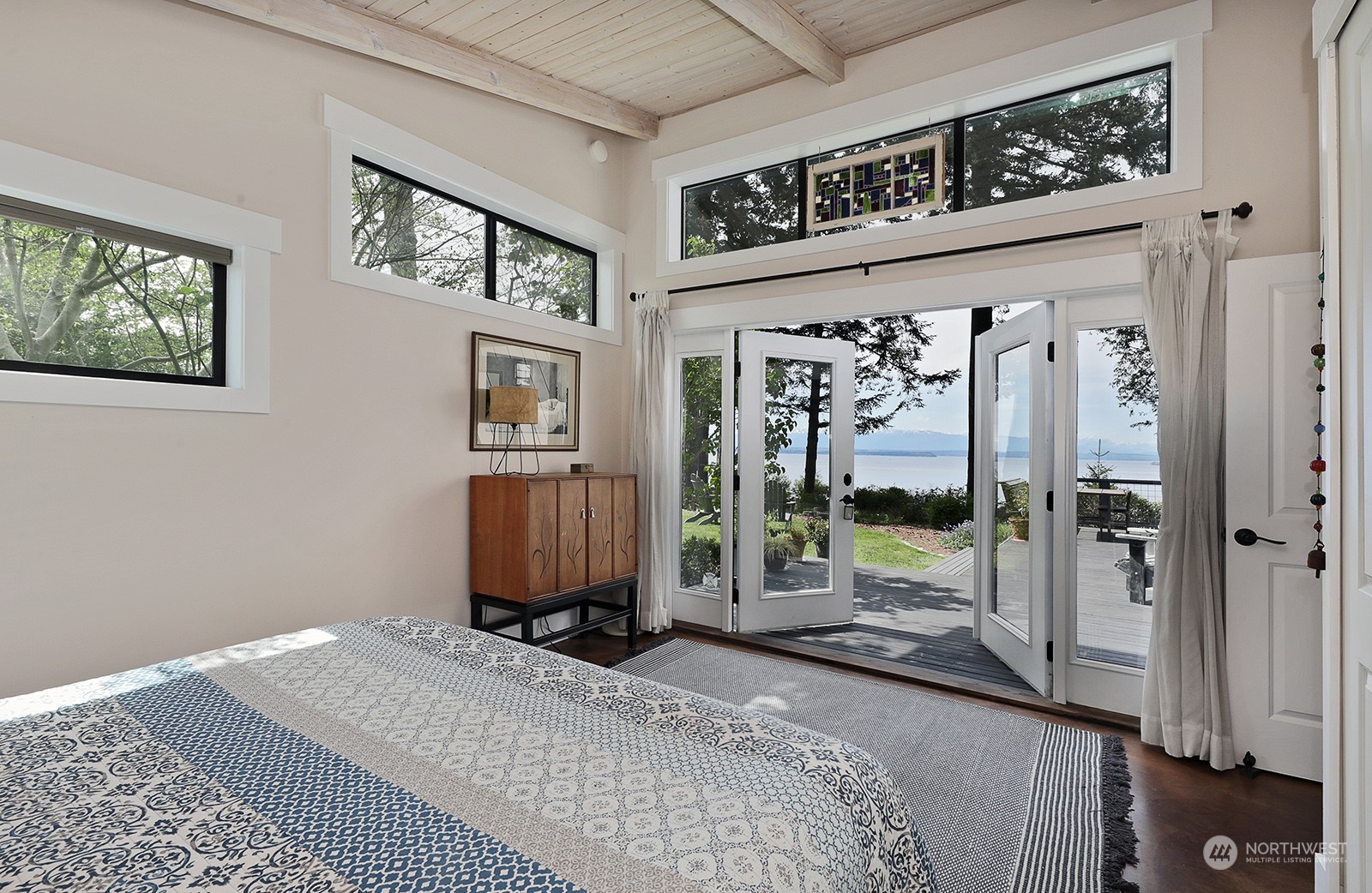 6828 Sills Road Clinton, WA 98236 - Photo 19 of 40 a bedroom with a bed a mirror and a window