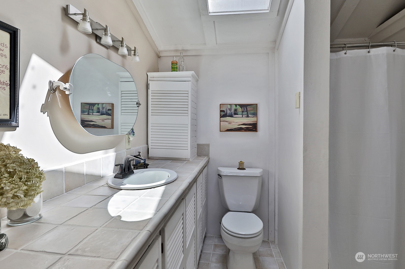 6828 Sills Road Clinton, WA 98236 - Photo 25 of 40 a bathroom with a granite countertop toilet sink and mirror