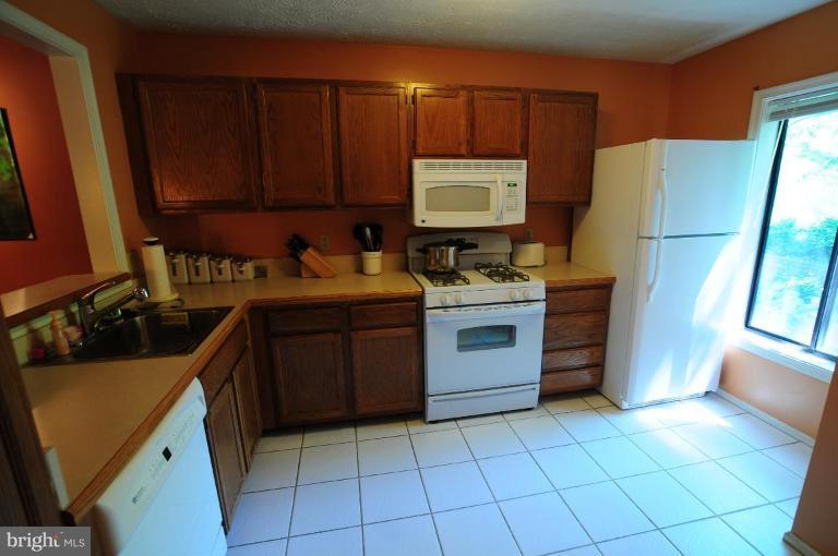 2297 Hunter's Run Drive, Unit 2297 Reston, VA 20191 - Photo 5 of 17 a kitchen with a stove sink and cabinets