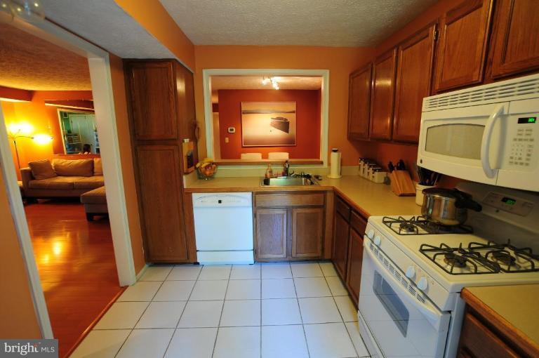 2297 Hunter's Run Drive, Unit 2297 Reston, VA 20191 - Photo 6 of 17 a kitchen with a stove a sink and a refrigerator