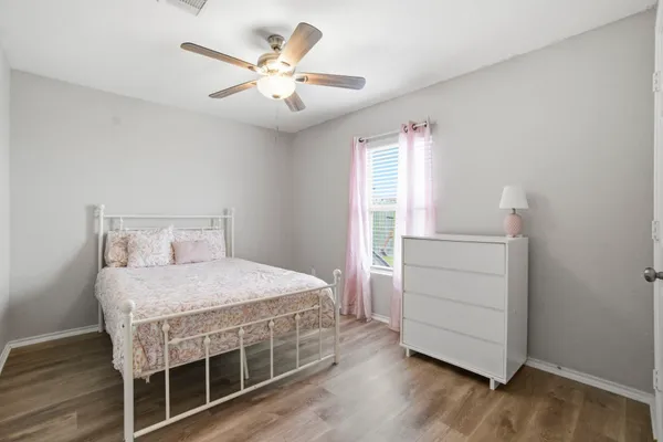 a bedroom with a bed and a ceiling fan