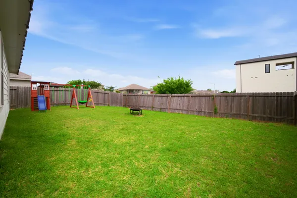 a view of a garden with a house in the background