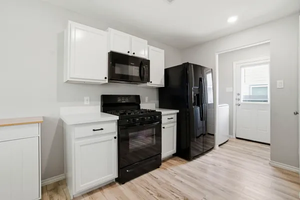 a kitchen with stainless steel appliances a refrigerator stove and microwave