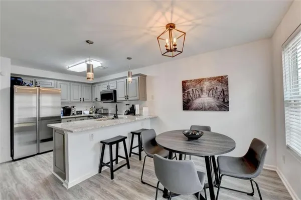 a view of a dining room with furniture a chandelier and wooden floor