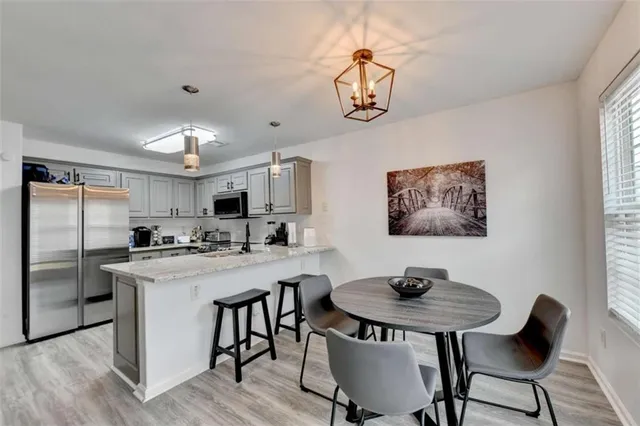 a view of a dining room with furniture a chandelier and wooden floor