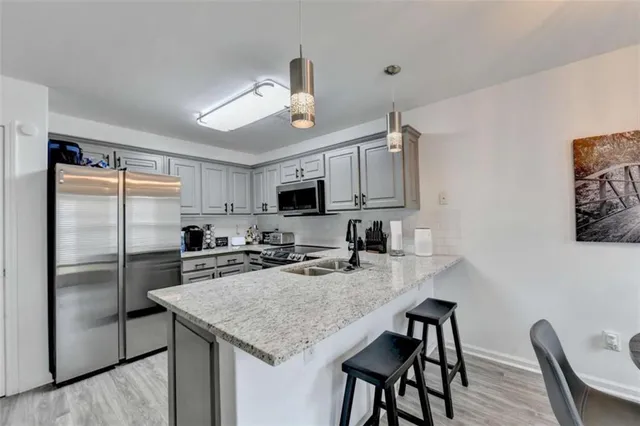 a kitchen with stainless steel appliances granite countertop a kitchen island a stove a table and chairs in it