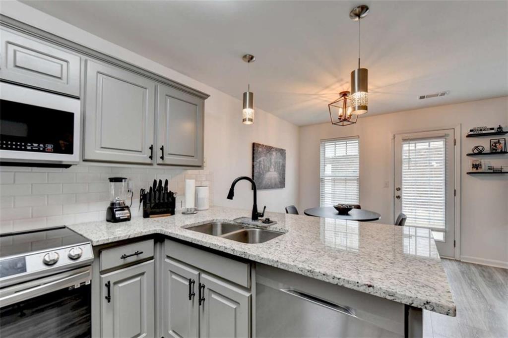 526 Terrapin Lane Winder, GA 30680 - Photo 14 of 40 a kitchen with stainless steel appliances granite countertop a sink a stove and cabinets