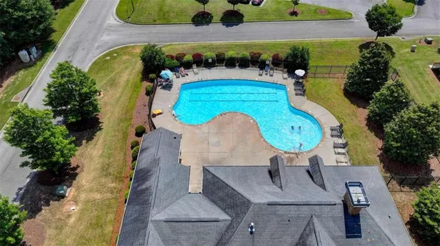 an aerial view of a swimming pool with outdoor seating
