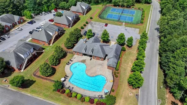 an aerial view of a house with a yard and greenery