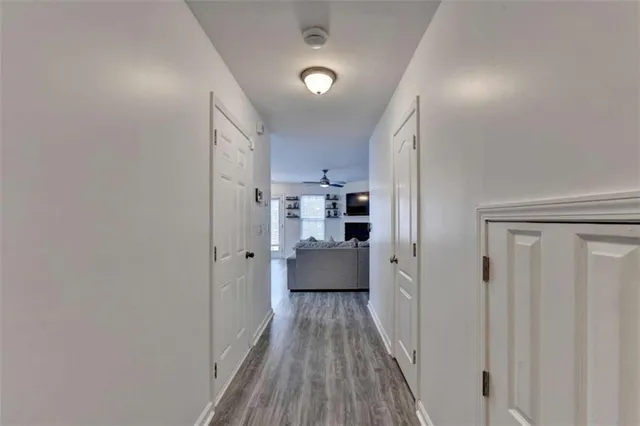 a view of a hallway with wooden floor and closet