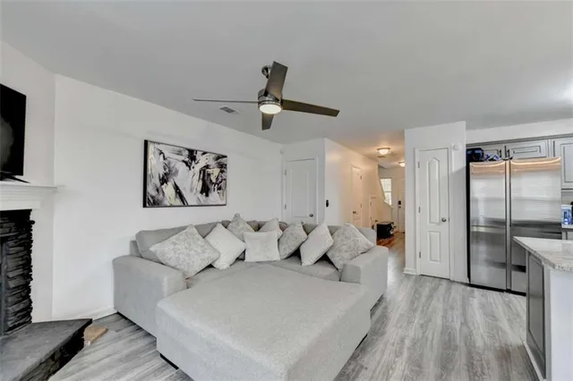 a living room with furniture and a ceiling fan
