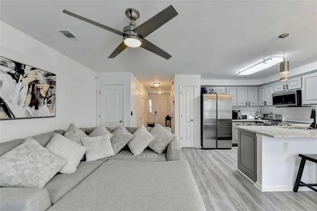 a living room with furniture and kitchen view
