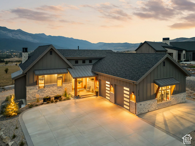 3929 Ridge Road Eden, UT 84310 - Photo 1 of 98 Mountain backdrop, stone and board-and-batten exterior, prominent entry porch, two-car garage with modern doors, concrete driveway