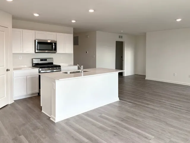 a kitchen with a sink a microwave and cabinets