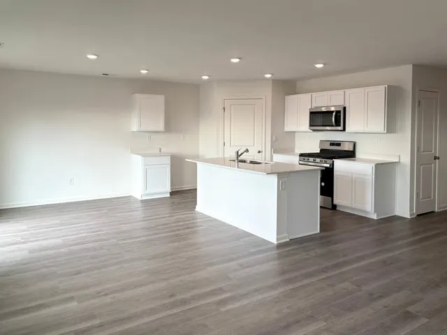 a kitchen with stainless steel appliances granite countertop a stove top oven a sink and a microwave