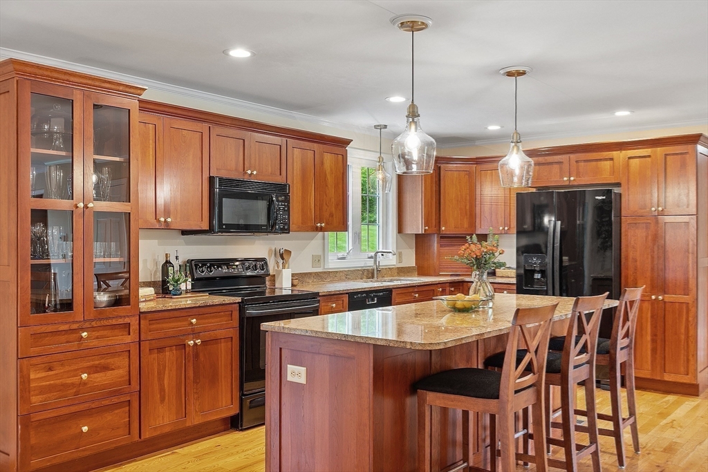 86 South Cross Road Haverhill, MA 01835 - Photo 12 of 42 a kitchen with a refrigerator a stove a sink a dining table and chairs with wooden floor