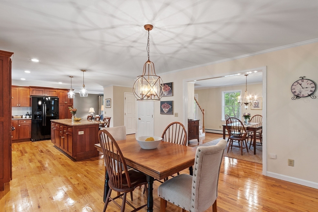 86 South Cross Road Haverhill, MA 01835 - Photo 14 of 42 a dining room with wooden floor a chandelier a wooden table and chairs