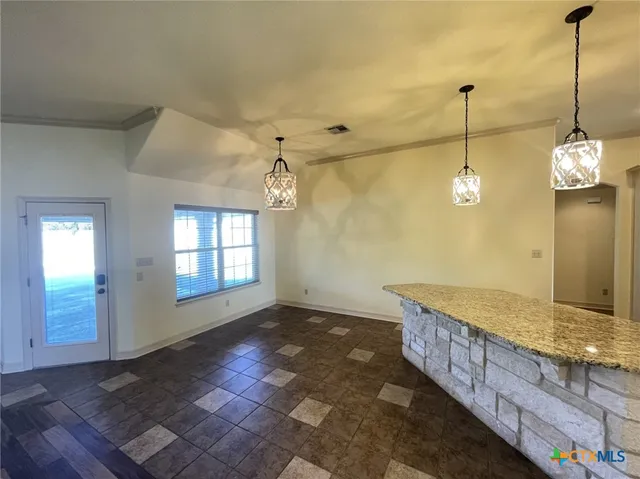 a view of a room with a chandelier fan and windows