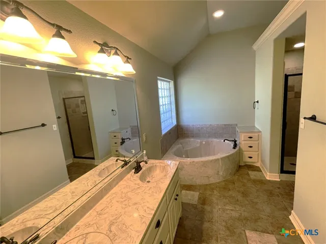 a bathroom with a granite countertop sink a toilet a mirror and bathtub