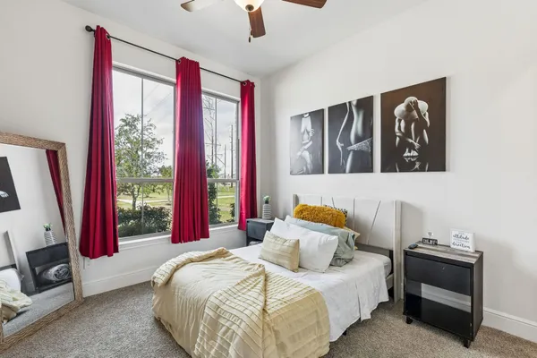 a bedroom with a bed and a large window