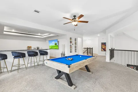 a living room with furniture and a pool table