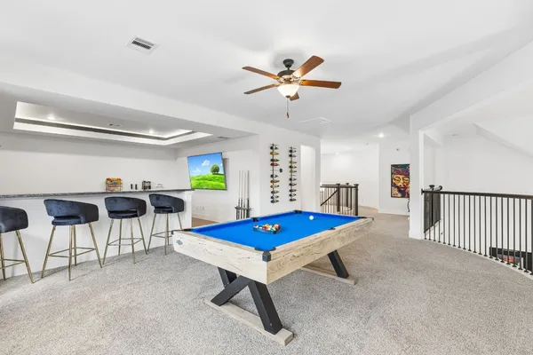 a living room with furniture and a pool table