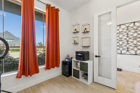 a view of a bedroom with wooden floor and a window