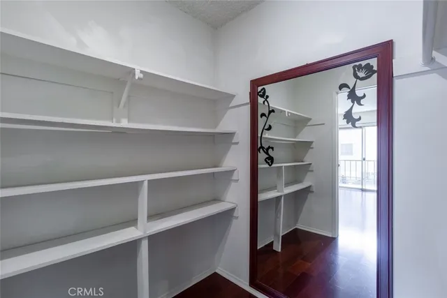 a view of a hallway with wooden floor and closet