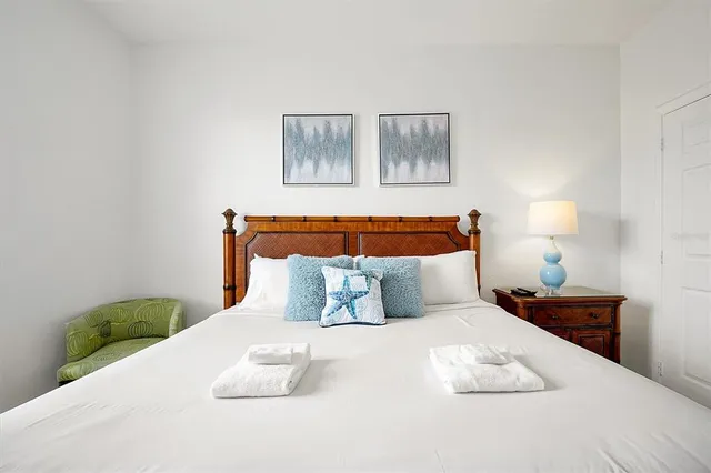 a bedroom with a bed and painting on the wall