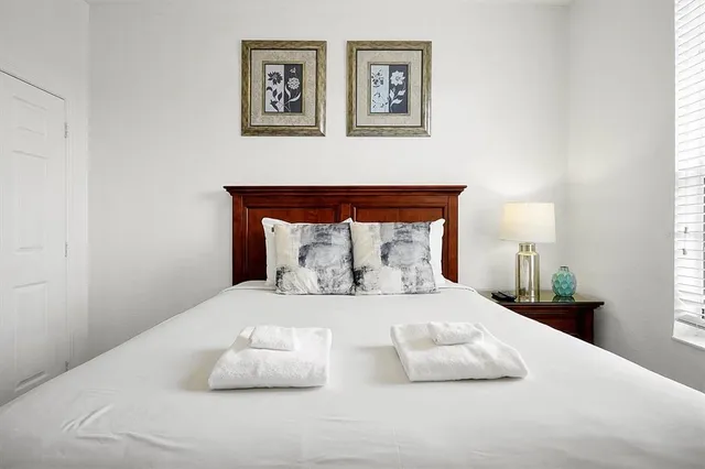 a bedroom with a bed and painting on the wall