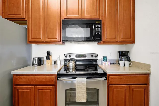 a kitchen with granite countertop wood cabinets and stainless steel appliances