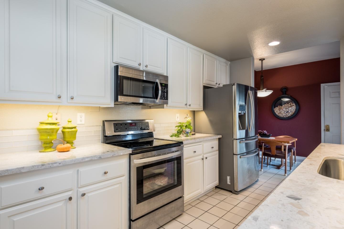 100 Farallon Drive Belmont, CA 94002 - Photo 8 of 29 a kitchen with stainless steel appliances granite countertop a stove a refrigerator and a white cabinets