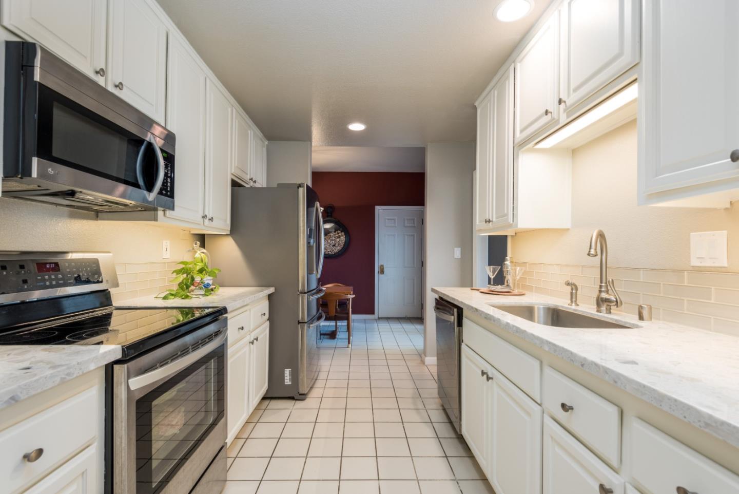 100 Farallon Drive Belmont, CA 94002 - Photo 9 of 29 a kitchen with a sink stainless steel appliances a stove a microwave and cabinets