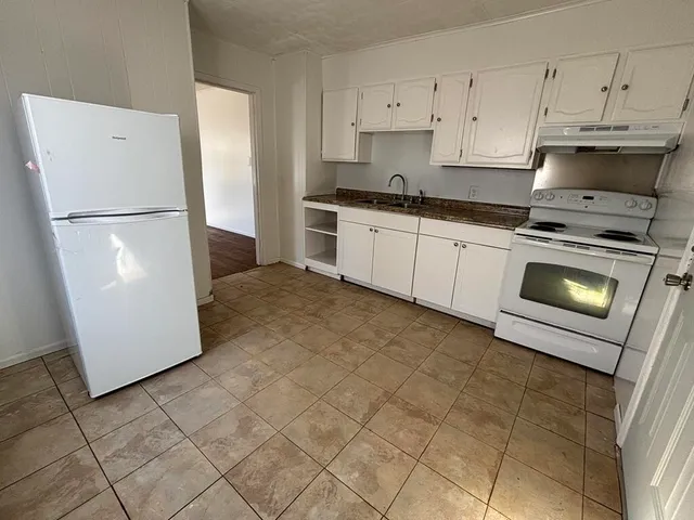 a kitchen with cabinets a refrigerator and a stove
