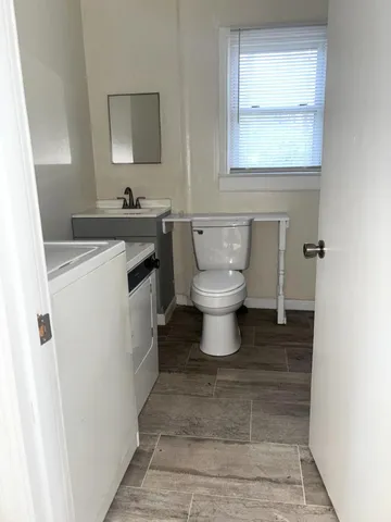 a bathroom with a granite countertop bathtub shower sink vanity and toilet