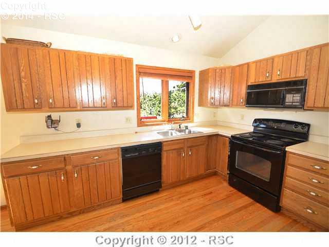 8660 Shoup Road Colorado Springs, CO 80908 - Photo 7 of 16 BRIGHT K ITCHEN WITH A KITCHEN SINK VIEW INTO THE TREES.