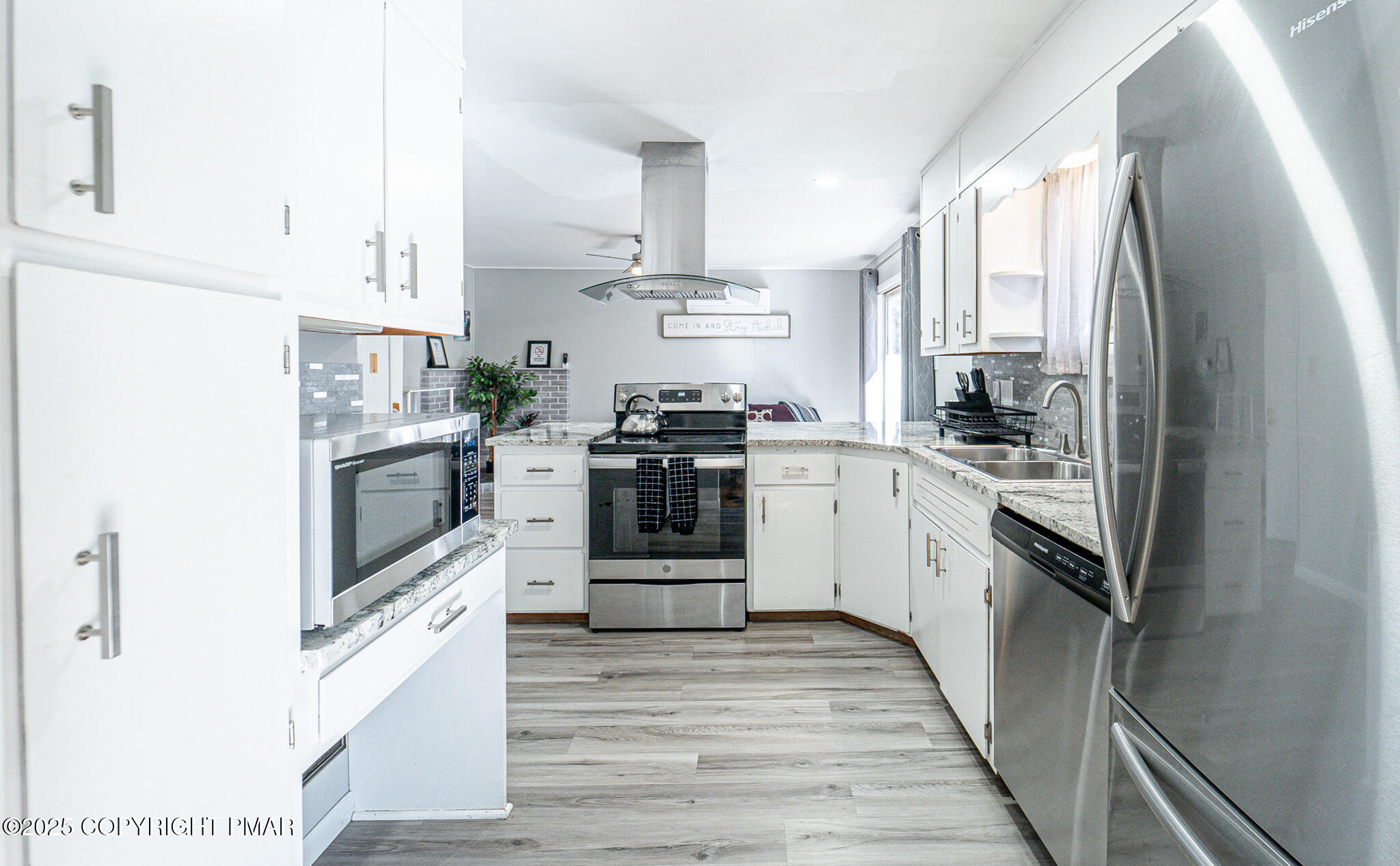2332 Highway 940 Pocono Summit, PA 18346 - Photo 14 of 65 a kitchen with stainless steel appliances granite countertop a refrigerator a stove a sink and white cabinets with wooden floor