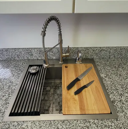 a kitchen with granite countertop a sink a counter top space cabinets and stainless steel appliances