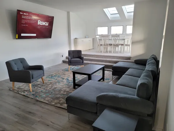 a living room with furniture and a potted plant with wooden floor
