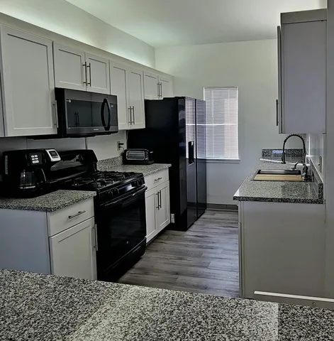 a kitchen with a refrigerator stove and wooden cabinets