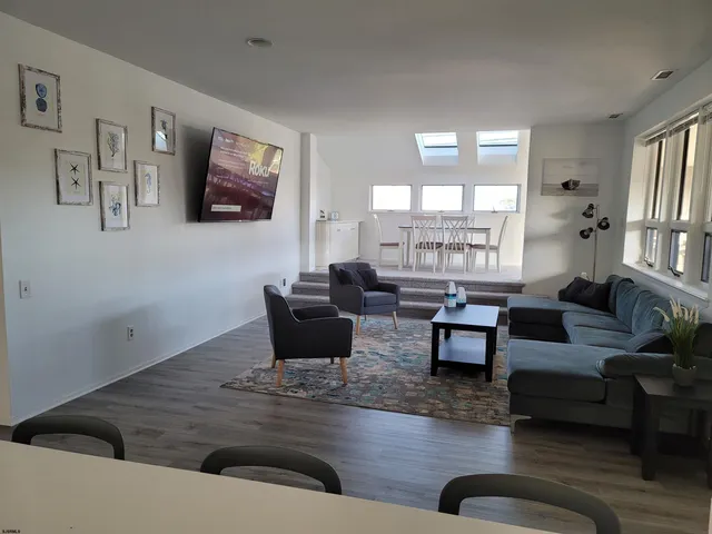 a living room with furniture and a potted plant with wooden floor