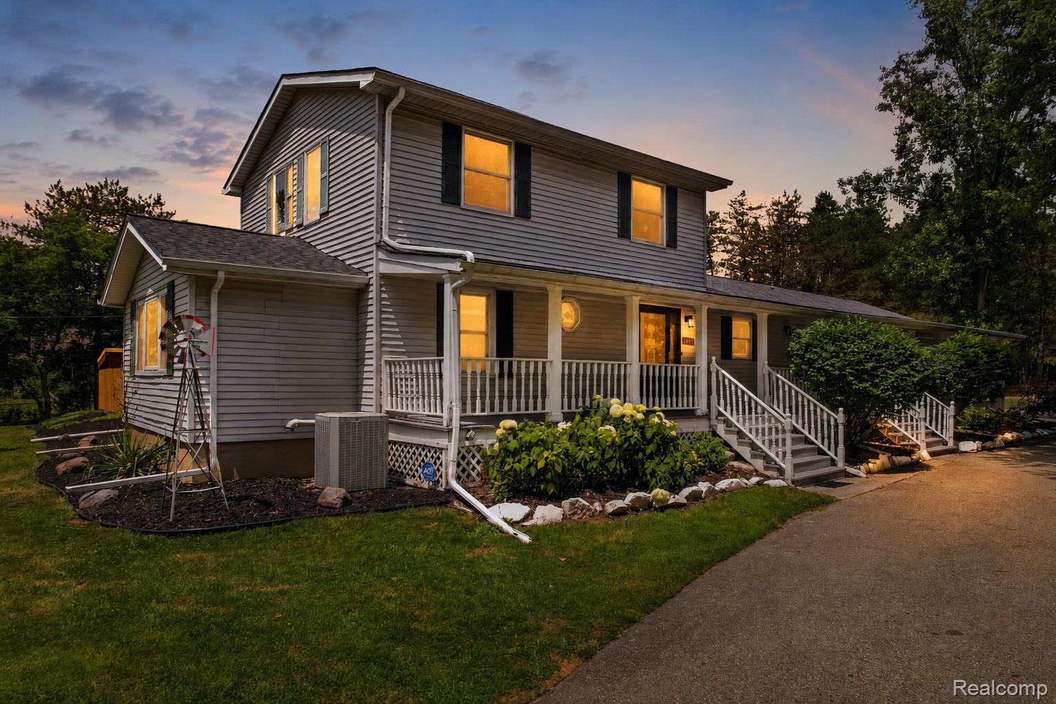 Two-story home featuring gray horizontal siding and black window shutters