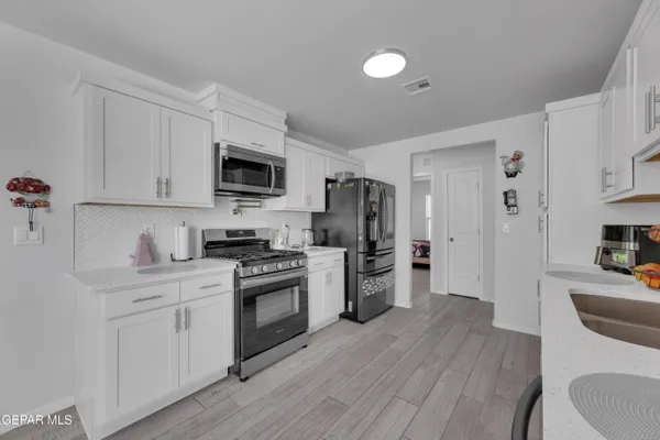a kitchen with stainless steel appliances a stove refrigerator sink and microwave