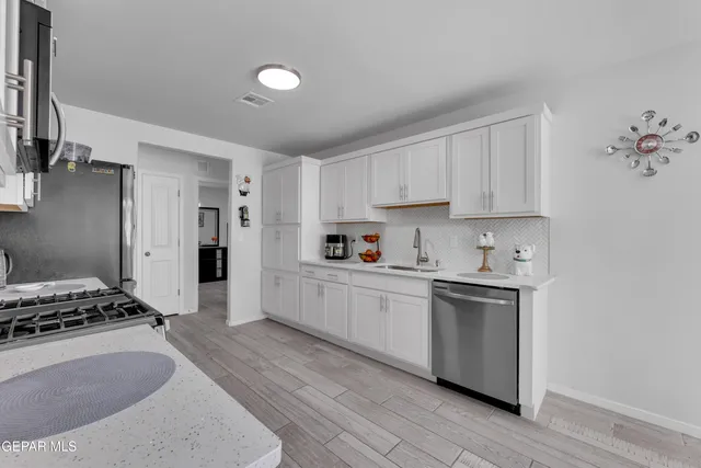 a kitchen with stainless steel appliances granite countertop a stove a sink and a refrigerator