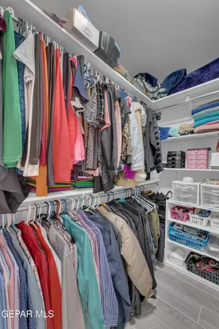 a view of walk in closet with clothes