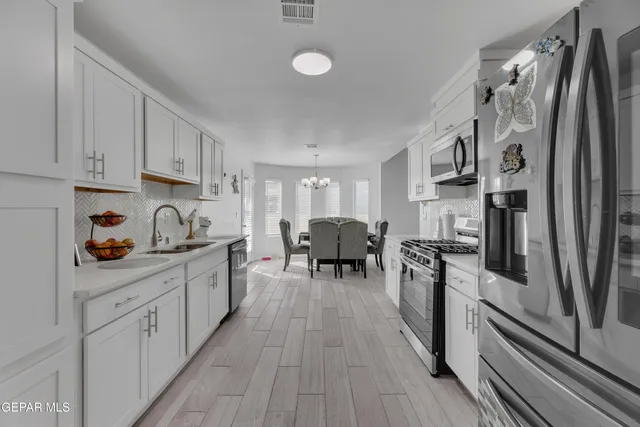 a kitchen with white cabinets and stainless steel appliances